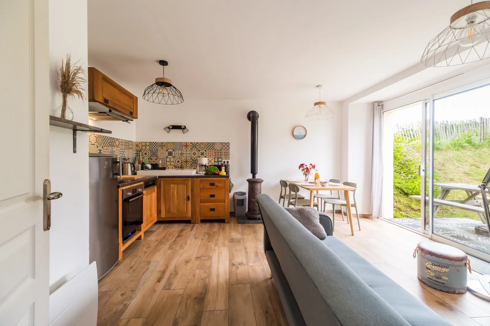 Living area: kitchen, wood stove and dining space opening onto the garden