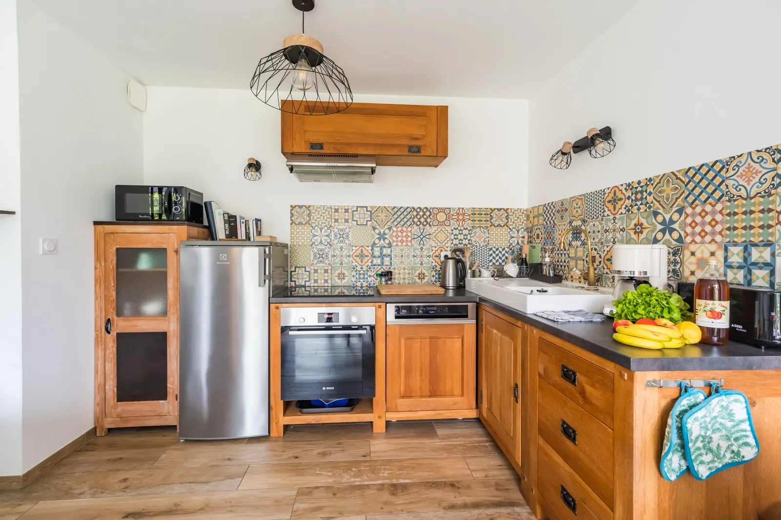 Fitted oak kitchen with patterned tile splashback